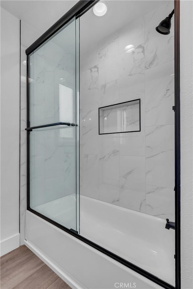 bathroom featuring bath / shower combo with glass door and wood finished floors