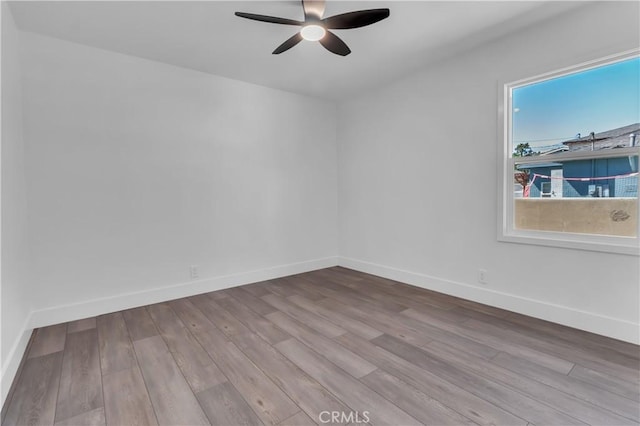 unfurnished room with baseboards, wood finished floors, and ceiling fan