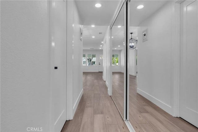 hallway with recessed lighting, baseboards, and light wood-style flooring