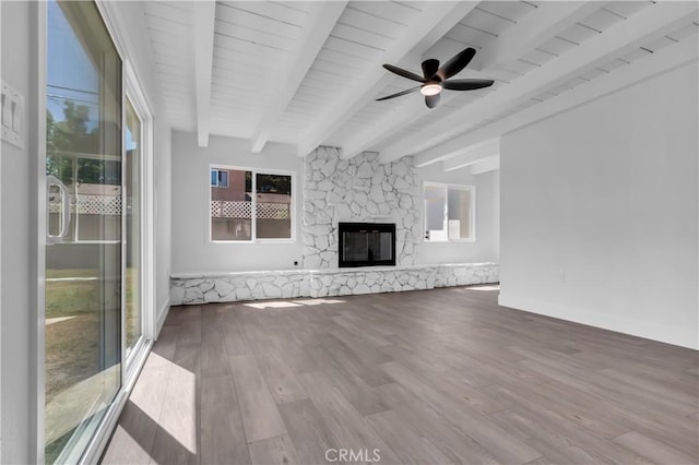 unfurnished living room featuring wood finished floors, beam ceiling, and a healthy amount of sunlight