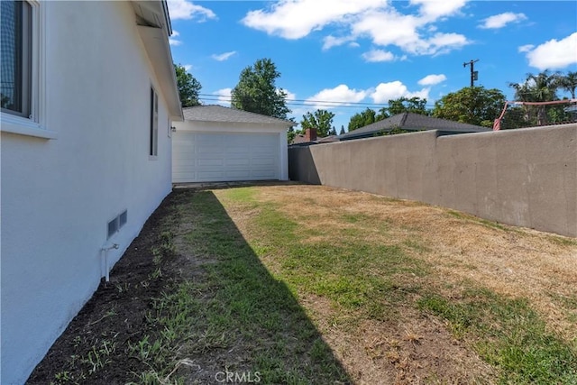 view of yard with fence and a garage