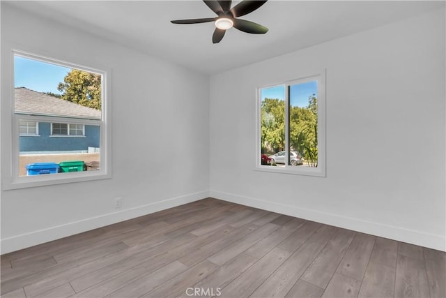 empty room featuring baseboards, a ceiling fan, and wood finished floors