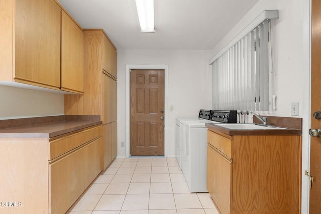 laundry room with cabinet space, washing machine and clothes dryer, light tile patterned floors, and a sink