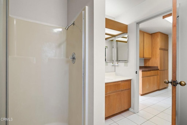 bathroom with tile patterned floors, vanity, and a shower