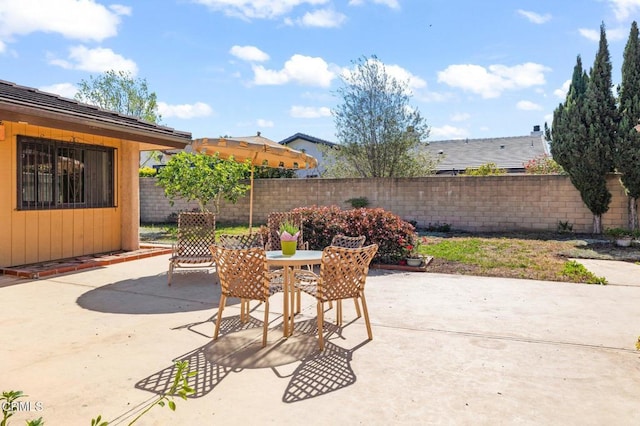 view of patio with outdoor dining area and fence