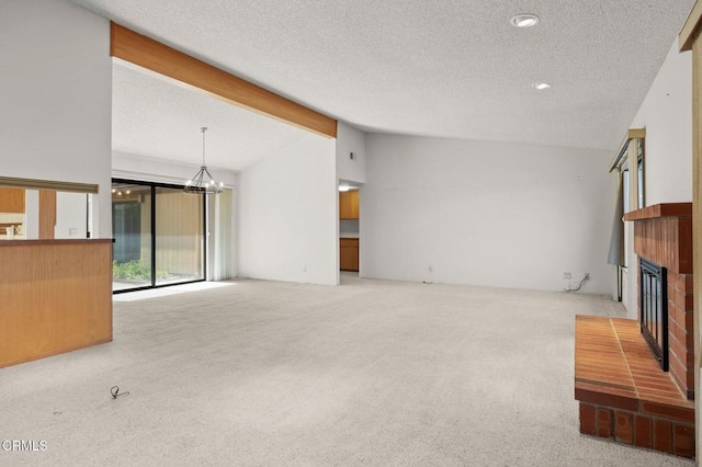 unfurnished living room featuring carpet, vaulted ceiling, a chandelier, and a fireplace