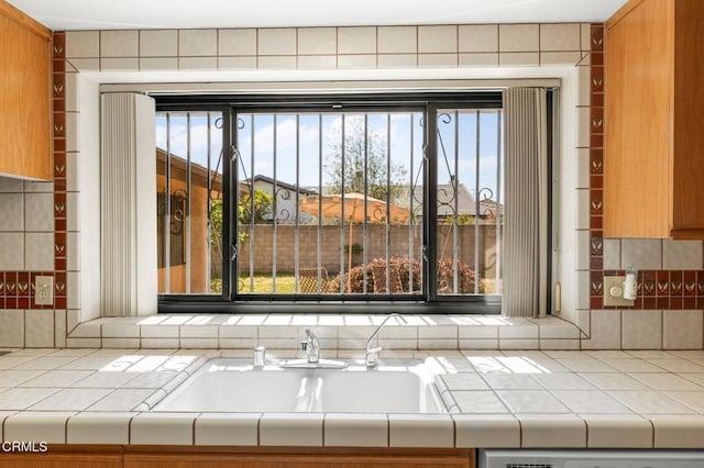 room details with dishwasher, tile countertops, and a sink
