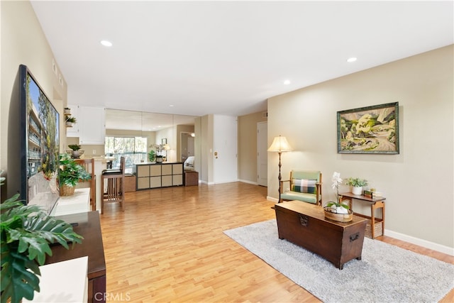 living area featuring recessed lighting, light wood-style flooring, and baseboards