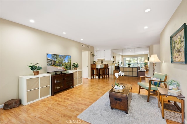 living area with recessed lighting and light wood finished floors