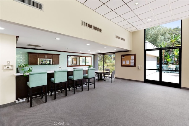 interior space with a high ceiling, visible vents, and carpet