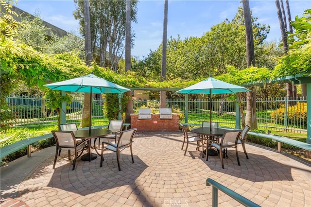 view of patio with fence, outdoor dining space, exterior kitchen, and area for grilling