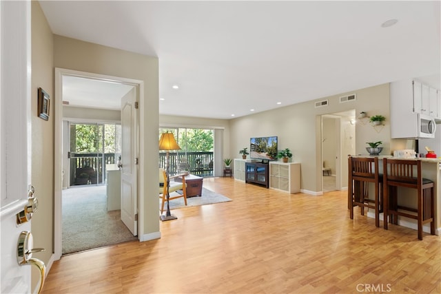 interior space with light wood-style flooring, visible vents, and plenty of natural light