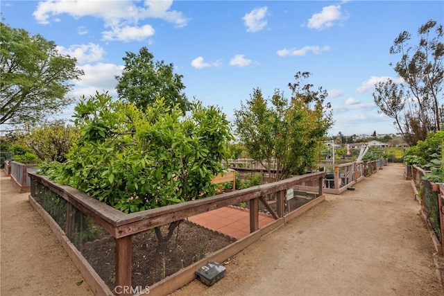 view of home's community with a garden and fence