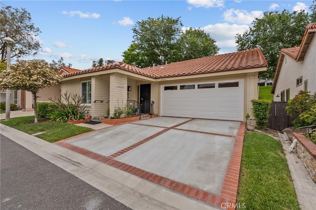 view of front of home featuring fence, stucco siding, an attached garage, a tile roof, and driveway