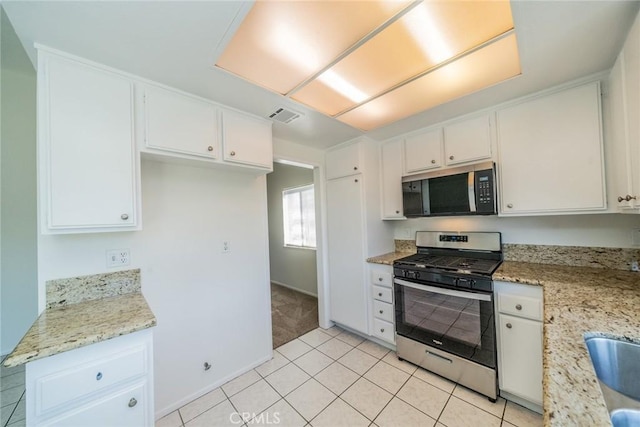 23607 Dracaea Ave, Moreno Valley, CA 92553 - kitchen featuring appliances with stainless steel finishes, white cabinets, light tile patterned flooring, light stone counters, and baseboards