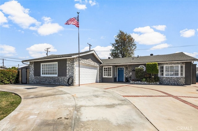 view of front facade featuring a garage, concrete driveway, and stone siding