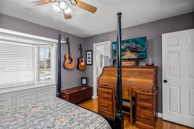 bedroom with baseboards, wood finished floors, and a ceiling fan