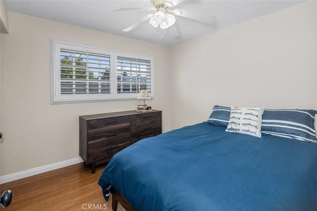 bedroom featuring a ceiling fan, wood finished floors, and baseboards