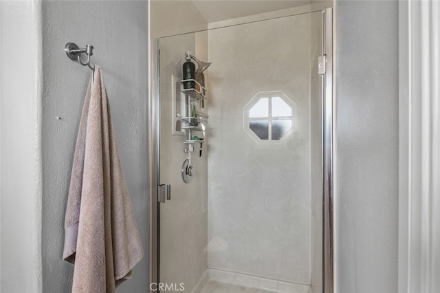 full bathroom with a textured wall and a shower stall