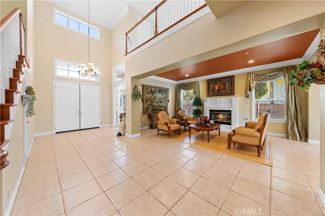 17265 Blue Spruce Ln, Yorba Linda, CA 92886 - foyer entrance with crown molding, light tile patterned floors, a glass covered fireplace, a chandelier, and baseboards