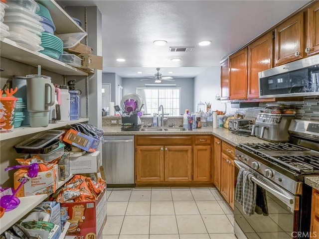 820 W Compton Blvd Unit 5, Compton, CA 90220 - kitchen featuring appliances with stainless steel finishes, a sink, a ceiling fan, light tile patterned flooring, and brown cabinetry