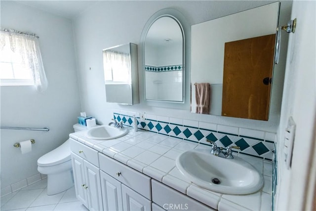 full bathroom featuring toilet, a sink, and a wealth of natural light