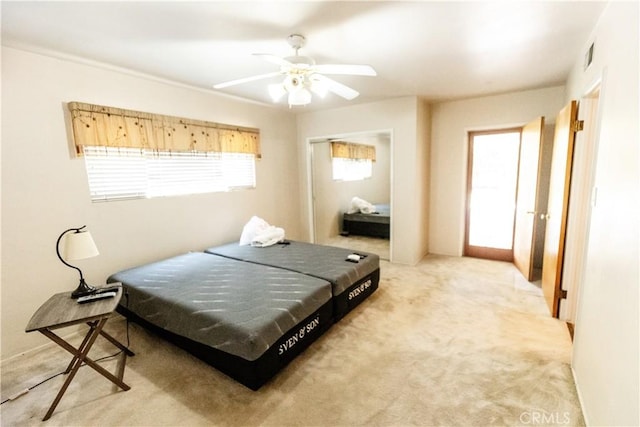 bedroom featuring a closet, ceiling fan, light carpet, and visible vents