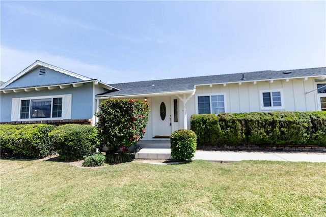 ranch-style home featuring board and batten siding and a front lawn