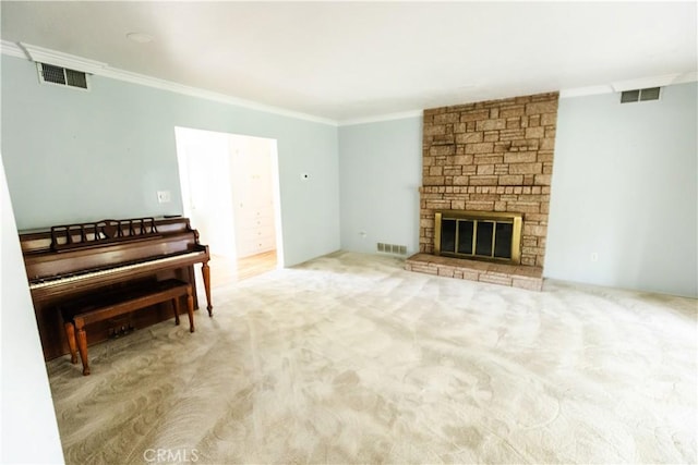 carpeted living room featuring crown molding, visible vents, and a stone fireplace