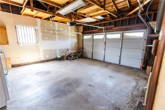 garage featuring a garage door opener and freestanding refrigerator