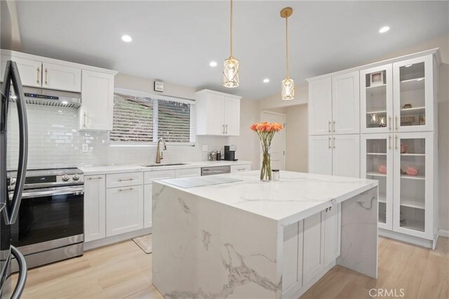 kitchen featuring a sink, stainless steel appliances, light wood-style flooring, white cabinets, and under cabinet range hood