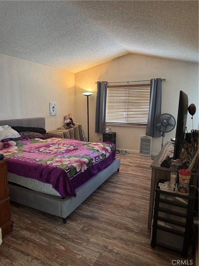 bedroom featuring a textured ceiling, vaulted ceiling, and wood finished floors
