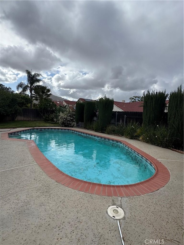 pool with a patio and a fenced backyard