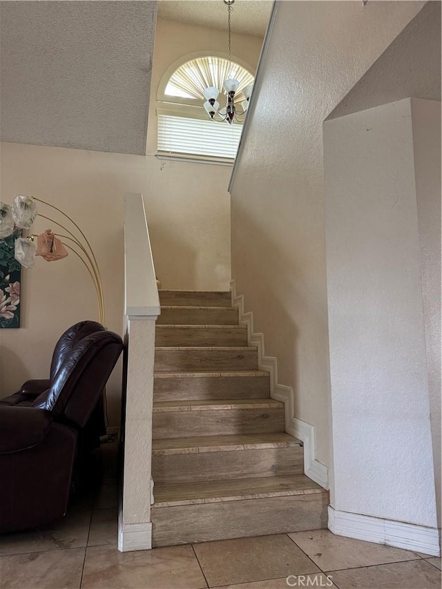 staircase featuring tile patterned floors and a chandelier