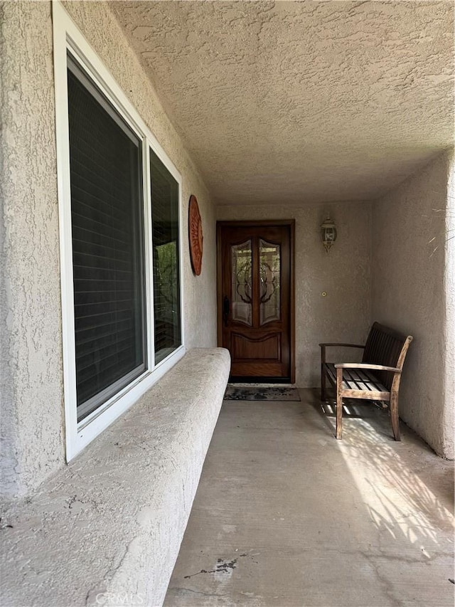 doorway to property with stucco siding and a porch