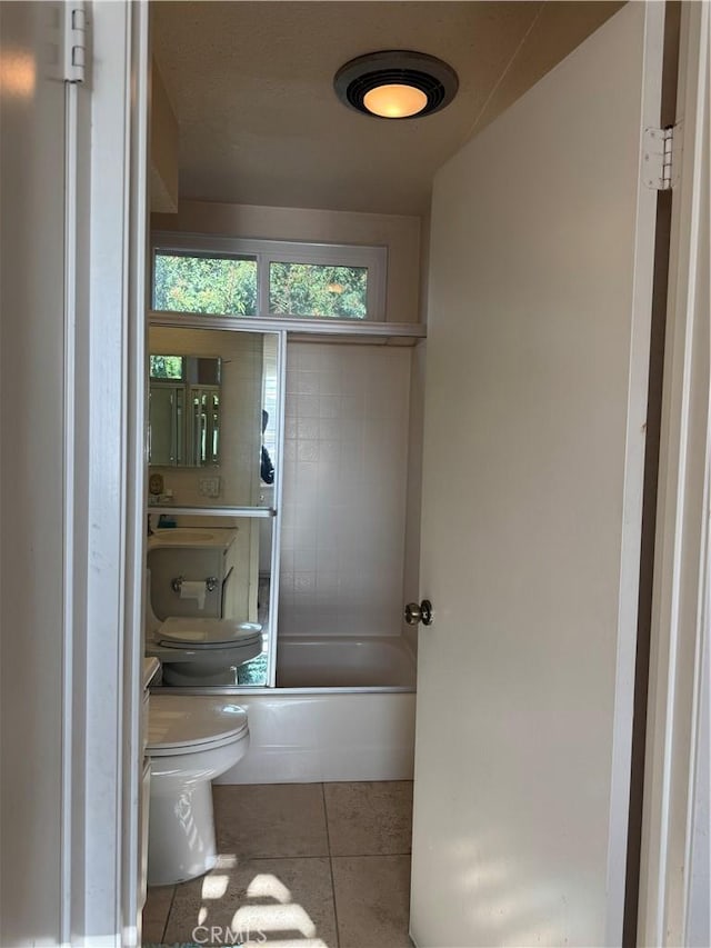 bathroom featuring toilet, shower / washtub combination, and tile patterned floors