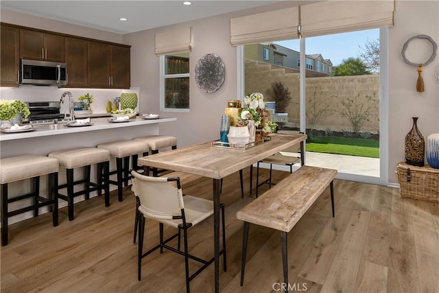 dining area with light wood-type flooring and recessed lighting
