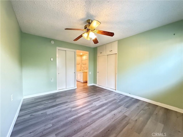 851 Ronda Mendoza Unit B, Laguna Woods, CA 92637 - unfurnished bedroom with wood finished floors, a textured ceiling, a ceiling fan, and a closet