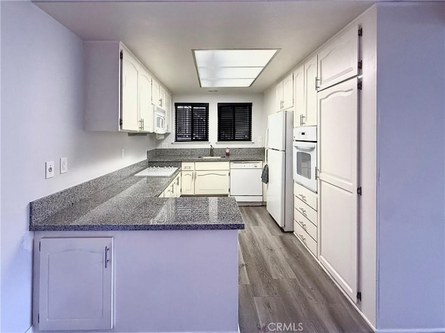 851 Ronda Mendoza Unit B, Laguna Woods, CA 92637 - kitchen featuring white appliances, a peninsula, white cabinetry, dark wood-type flooring, and dark stone counters