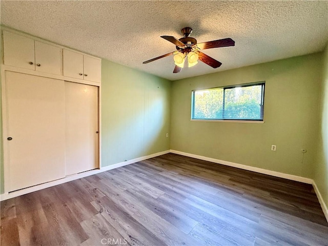 851 Ronda Mendoza Unit B, Laguna Woods, CA 92637 - unfurnished bedroom featuring a textured ceiling, wood finished floors, a closet, and ceiling fan