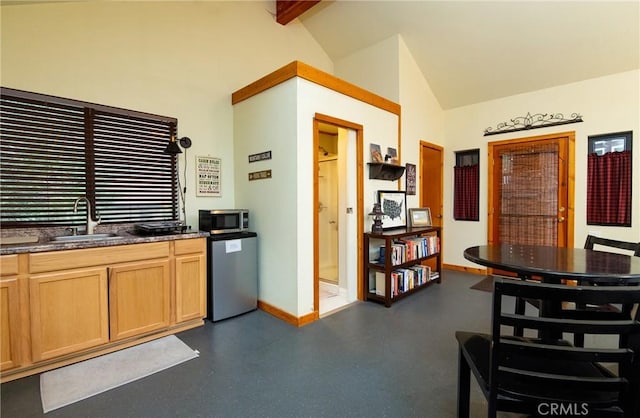 kitchen featuring dark countertops, dishwasher, a sink, stainless steel microwave, and baseboards