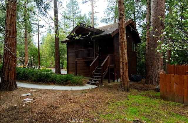 exterior space with stairway and roof with shingles