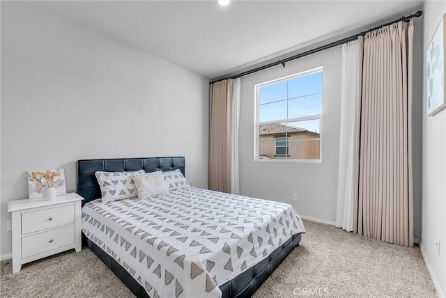 bedroom featuring baseboards and light colored carpet