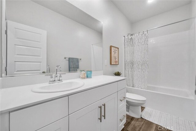 bathroom with shower / tub combo, toilet, vanity, and wood finished floors