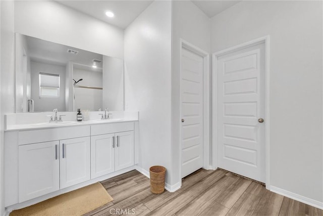 full bath featuring wood finished floors, baseboards, and a sink