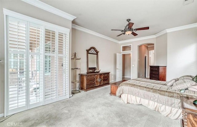 carpeted bedroom with visible vents, ornamental molding, arched walkways, baseboards, and access to outside