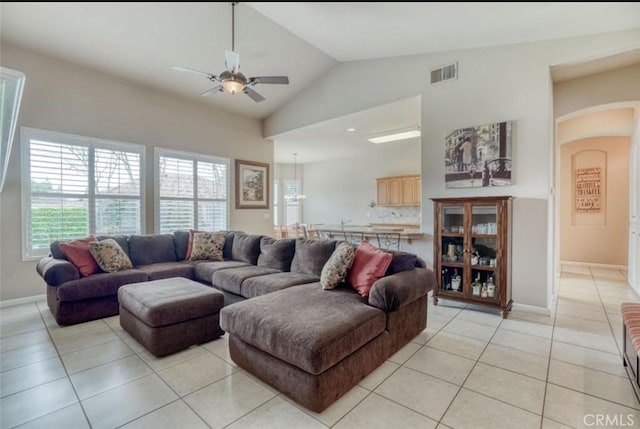 living room featuring a ceiling fan, light tile patterned floors, arched walkways, lofted ceiling, and visible vents