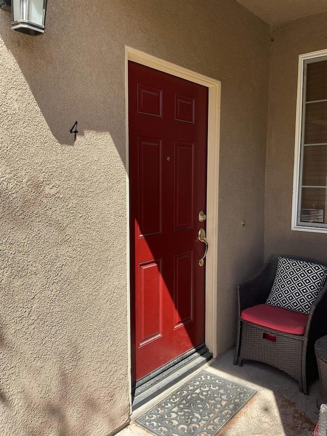 view of exterior entry with stucco siding