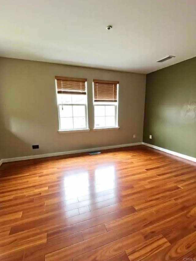 unfurnished room featuring wood finished floors and baseboards