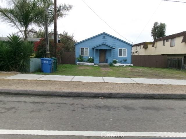 bungalow featuring fence and a front yard